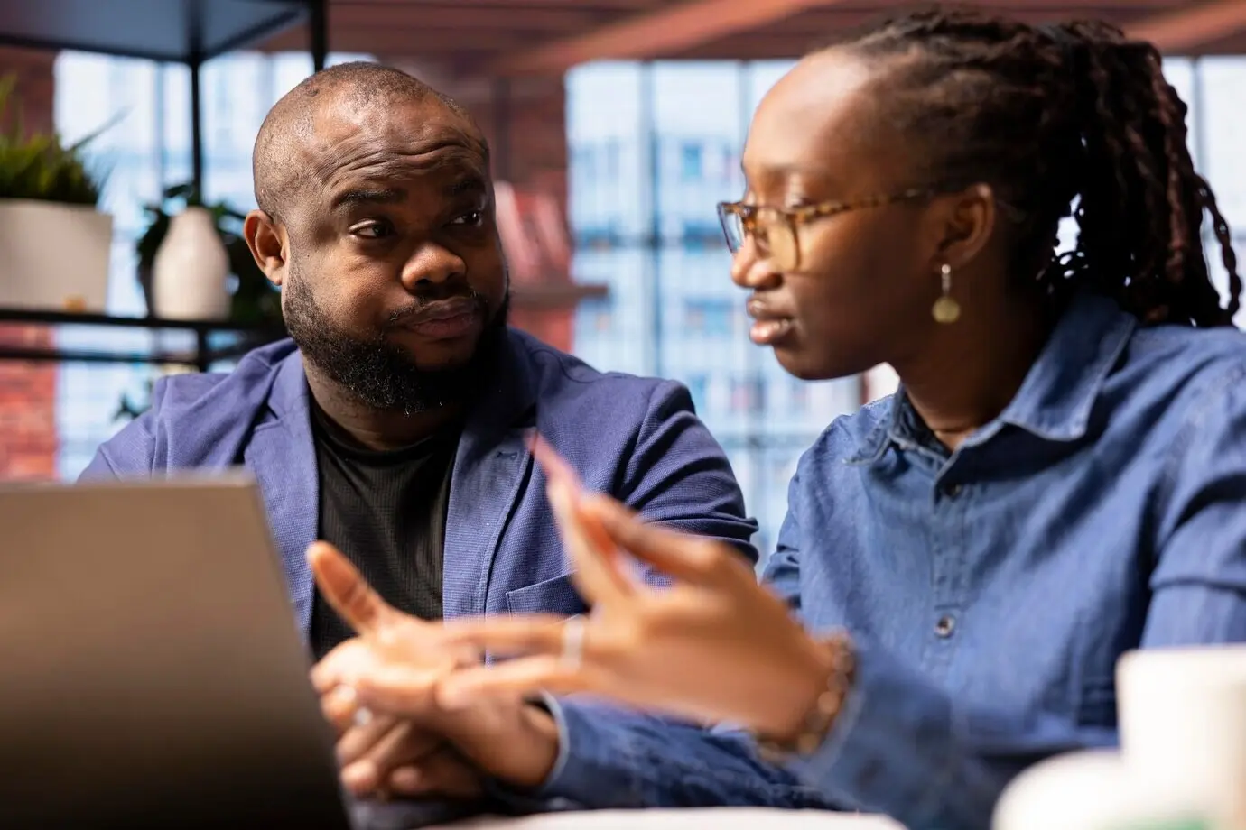 Ein glückliches Paar nimmt am Laptop Reservierungen für einen Familienurlaub vor.