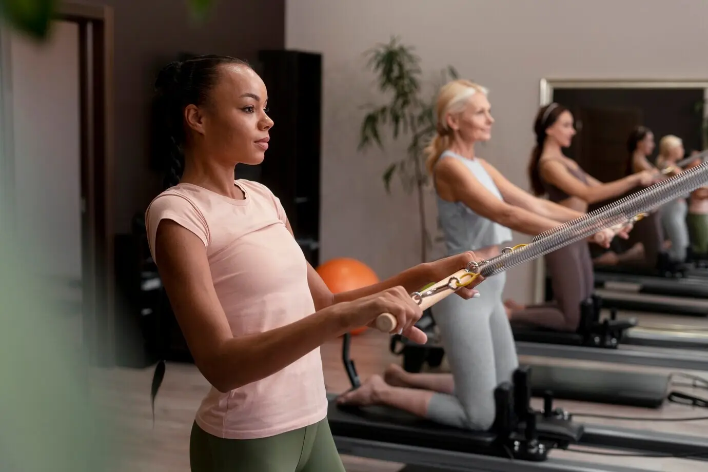 Menschen in einem Pilates-Reformer-Kurs, die ihren Körper trainieren.
